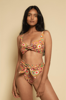 Mustard yellow bikini top with red, orange, and green floral print and center bow detail.