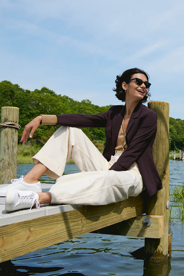 image of a woman sitting on a dock wearing the milo jean in tusk | Exclude
