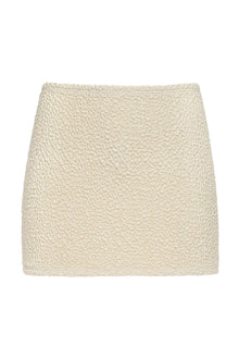 Cream-colored textured micro skirt with quilted surface pattern and high waistband.