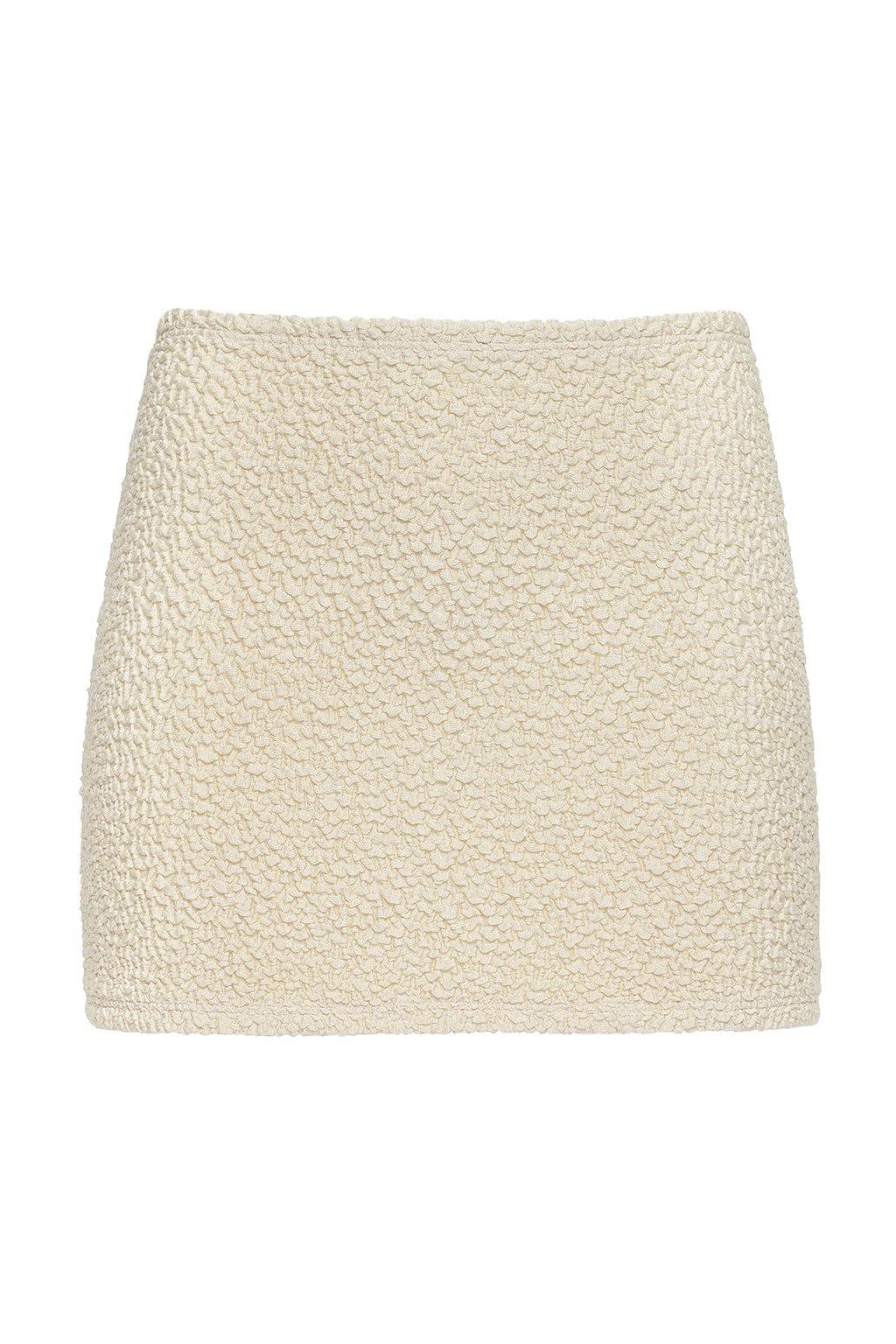 Cream-colored textured micro skirt with quilted surface pattern and high waistband.