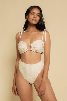 Oat-colored textured bikini bottom with high-waisted cut and textured fabric detail.