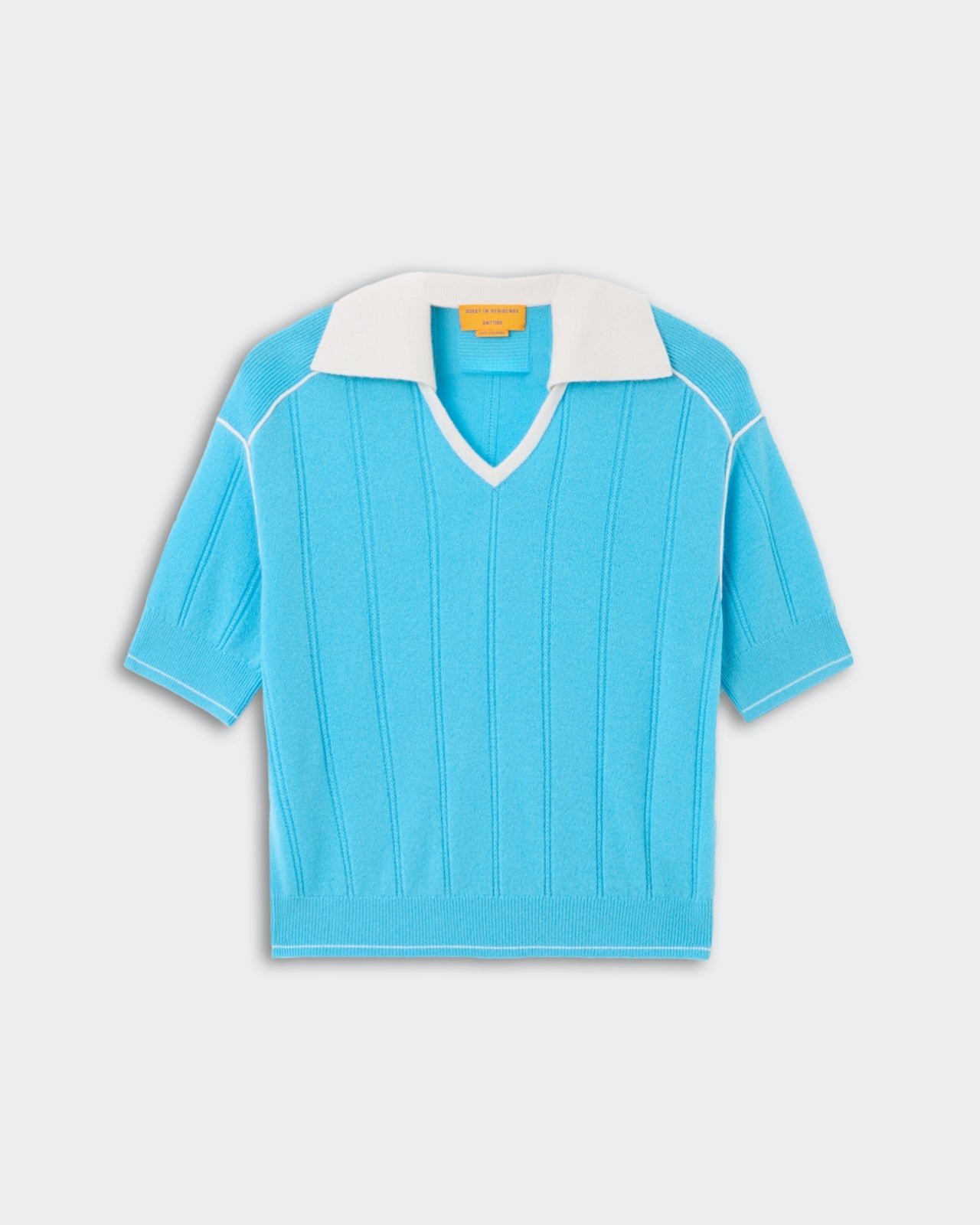 Pele Polo - Swimming Pool/Cream, a short-sleeve knit top in bright swimming pool blue with subtle vertical ribbing, featuring a contrasting cream open collar and white piping accents on shoulders and sleeves, displayed flat.