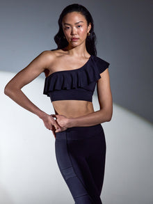 Model wearing the Ruffle One Shoulder Bra in Diamond Compression Black under studio lighting, front view