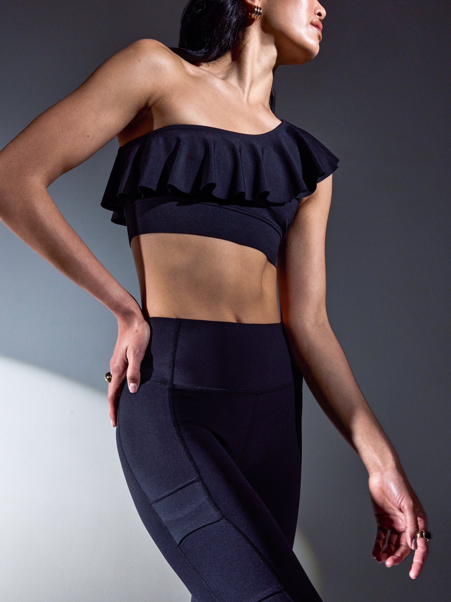 Side angle of the Ruffle One Shoulder Bra in Diamond Compression Black showing ruffle detail and one-shoulder fit.