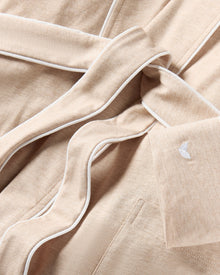 The Women's Pima Robe in Camel features white trim, long sleeves, two front pockets, and a matching waist belt, shown on a white background.