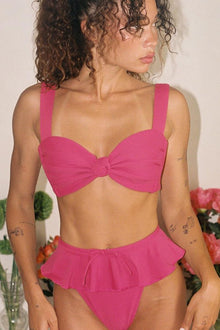 Hot pink bikini bottom with ruffled waistband and side ties.