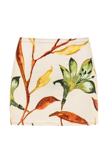 Cream mini skirt with botanical print featuring rust, yellow, and green branches and leaves.