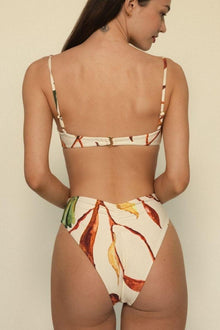 Cream bikini bottom with red, yellow, and green leaf print pattern, high-waisted cut, shown from back view.
