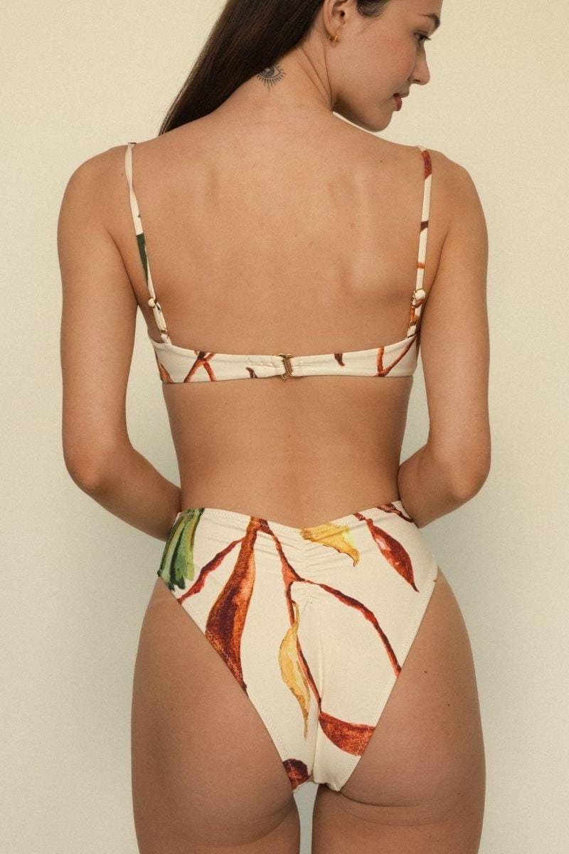 Cream bikini bottom with red, yellow, and green leaf print pattern, high-waisted cut, shown from back view.