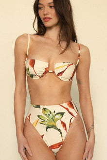 High-waisted bikini bottom with red and yellow floral print on cream background.