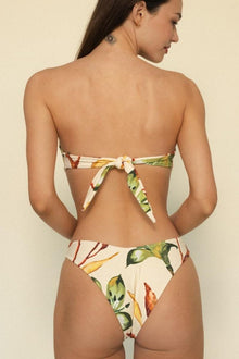 Bandeau bikini top with floral print in cream, green, yellow, and red tones, featuring tie closure at back.