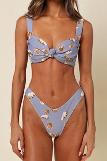 Lavender bikini bottom with gold shell pattern and zig-zag stitched edges on model.