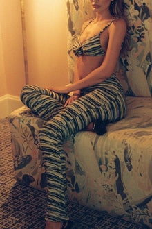 Woman wearing striped flared leggings with horizontal navy and white stripes in textured knit fabric.