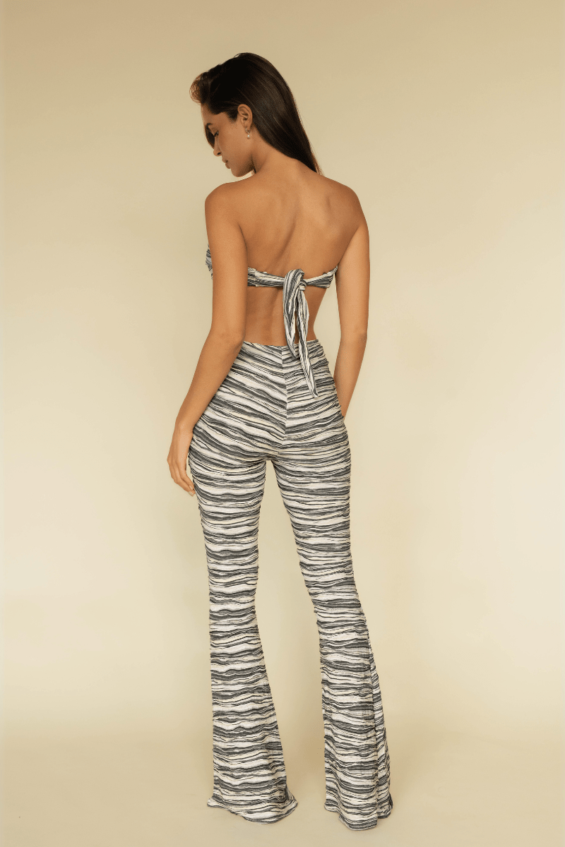 Black and white striped flared legging with textured knit fabric, shown from back view on model.
