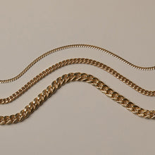 Model Three gold chain necklaces on a beige background