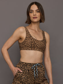 Model wears scoop neck sports bra with animal print, wide shoulder straps and a supportive fit.