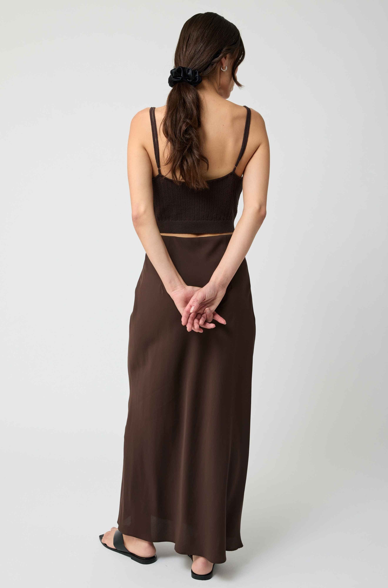 Woman wearing a brown dress with a plain white background