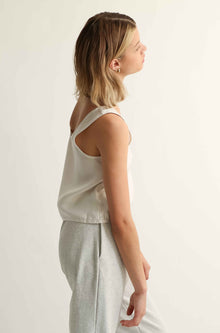 Woman wearing a sleeveless top on a light grey background