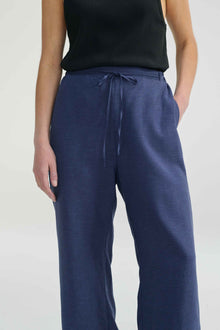 Woman wearing blue linen pants with a tie waist