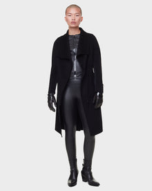 A person with a shaved head models the RUDSAK CHAY - 8122506 BLACK overcoat, leather top, gloves, pants, and ankle boots against a plain light gray background.