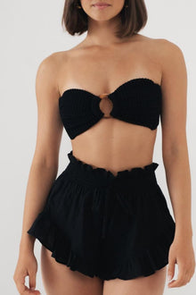 Black strapless bikini top with center ring detail and matching ruffled shorts.