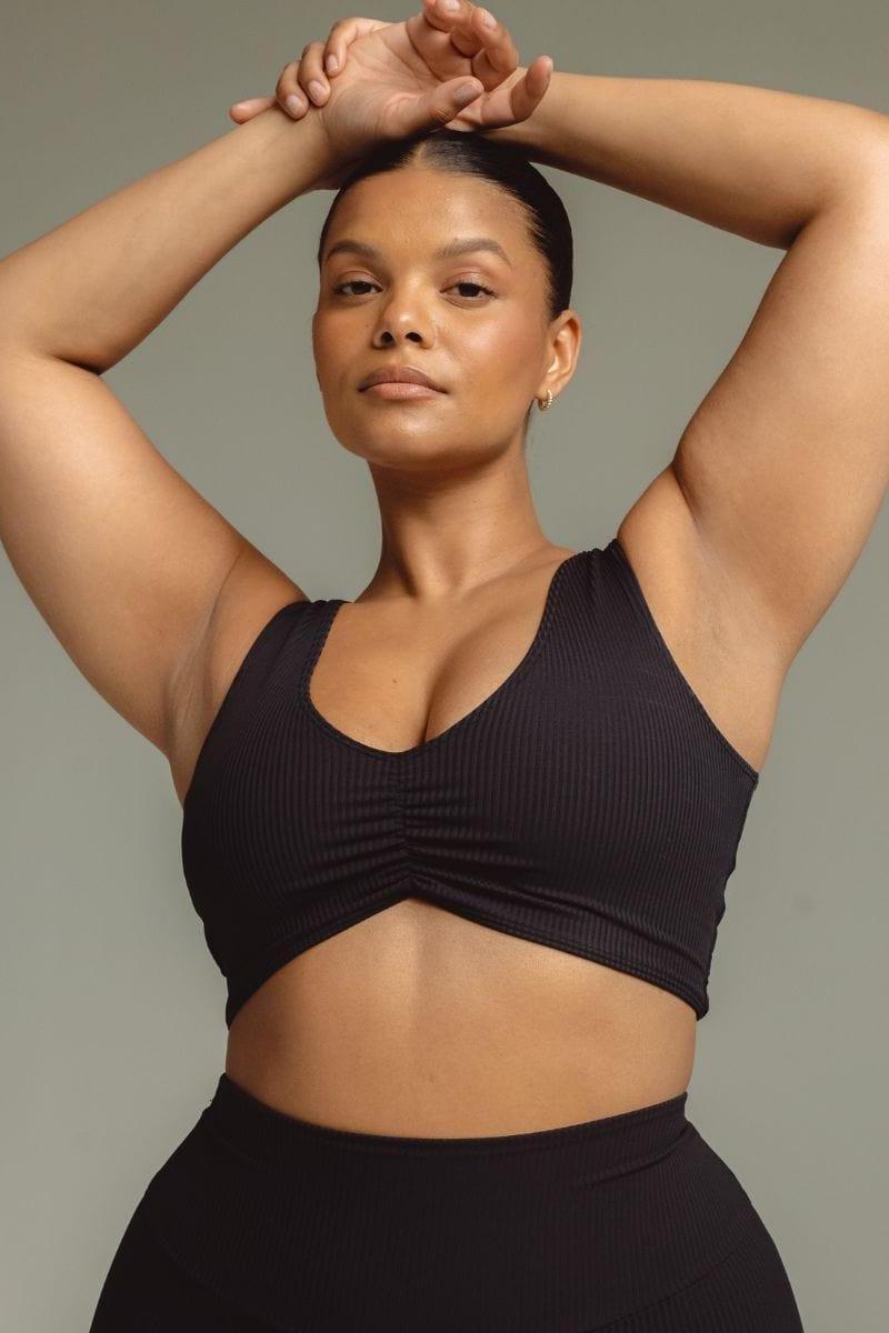 Black ribbed bikini top with V-neckline and ruched center detail, shown on model.