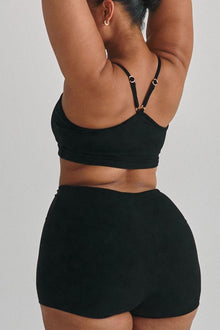 Black ribbed micro shorts with high-waisted fit shown on model from back view.