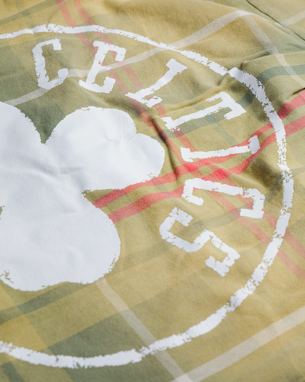 Close-up of Boston Celtics logo on heavyweight cotton twill Sports Flannel with plaid pattern