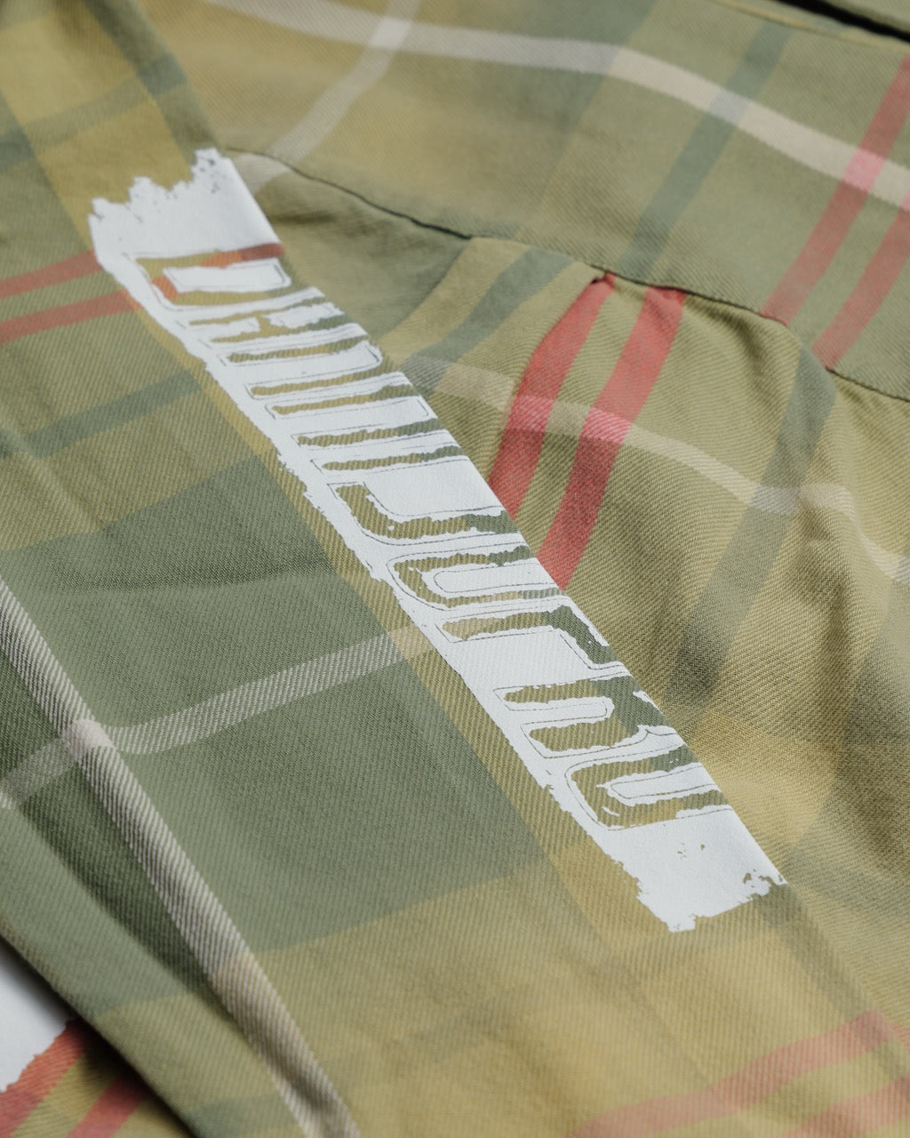 Close-up of Boston Celtics Sports Flannel in heavyweight cotton twill with oversized painterly logo and plaid pattern