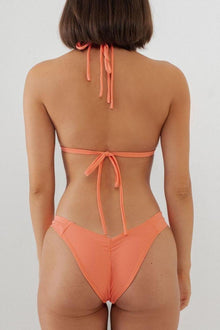 Coral bikini bottom with high-cut leg openings and tie-side closure, shown from back view.