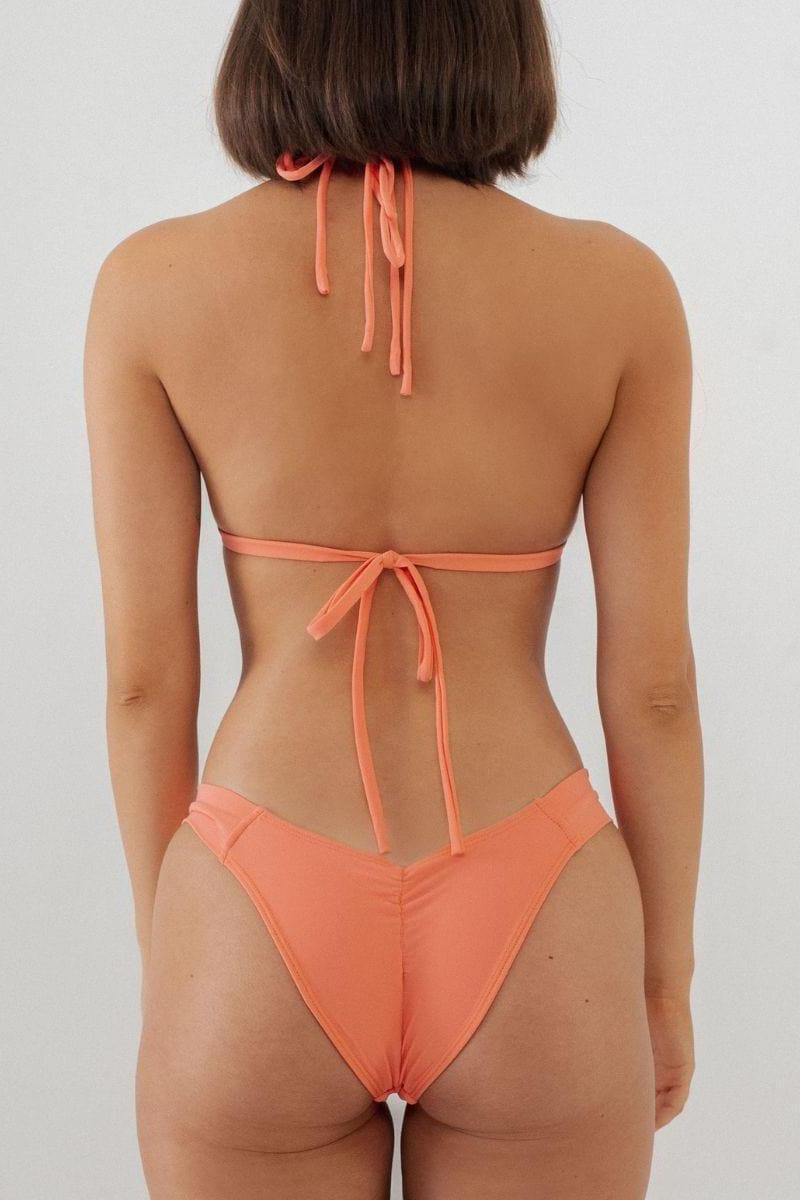 Coral bikini bottom with high-cut leg openings and tie-side closure, shown from back view.
