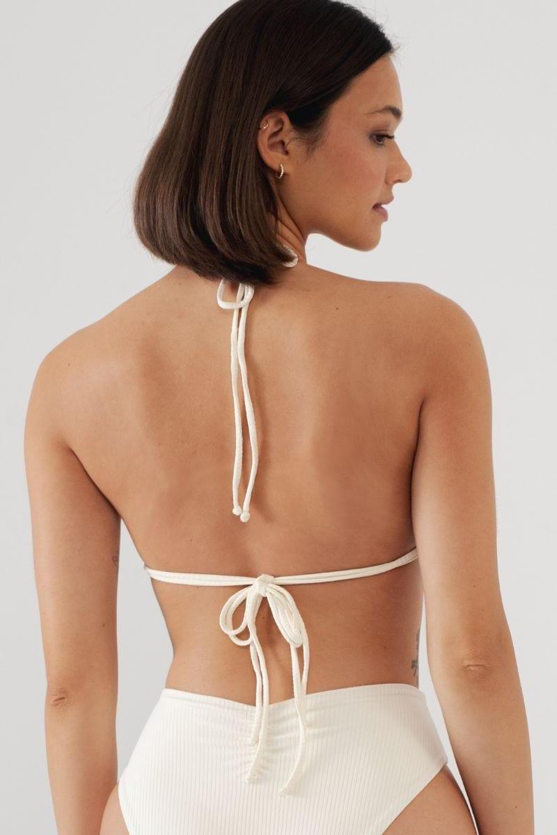 Cream ribbed bikini top with halter neck tie and adjustable back closure, shown from behind on a model.