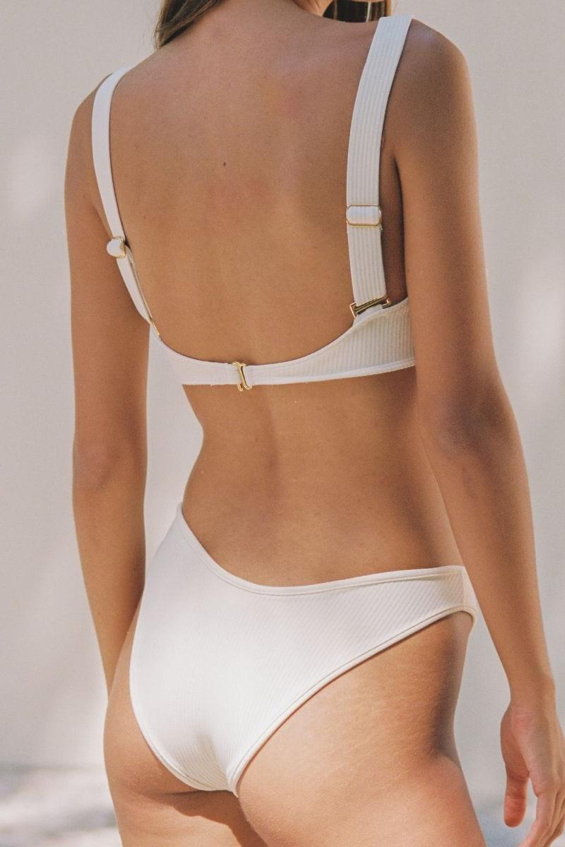 Cream ribbed bustier bikini top with thin straps and gold hardware, shown from back view.