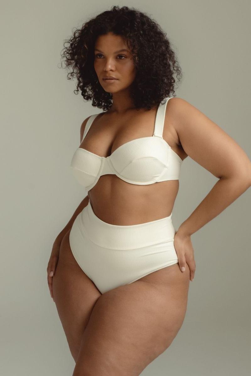 Cream ribbed bustier bikini top with underwire cups and adjustable straps on model.