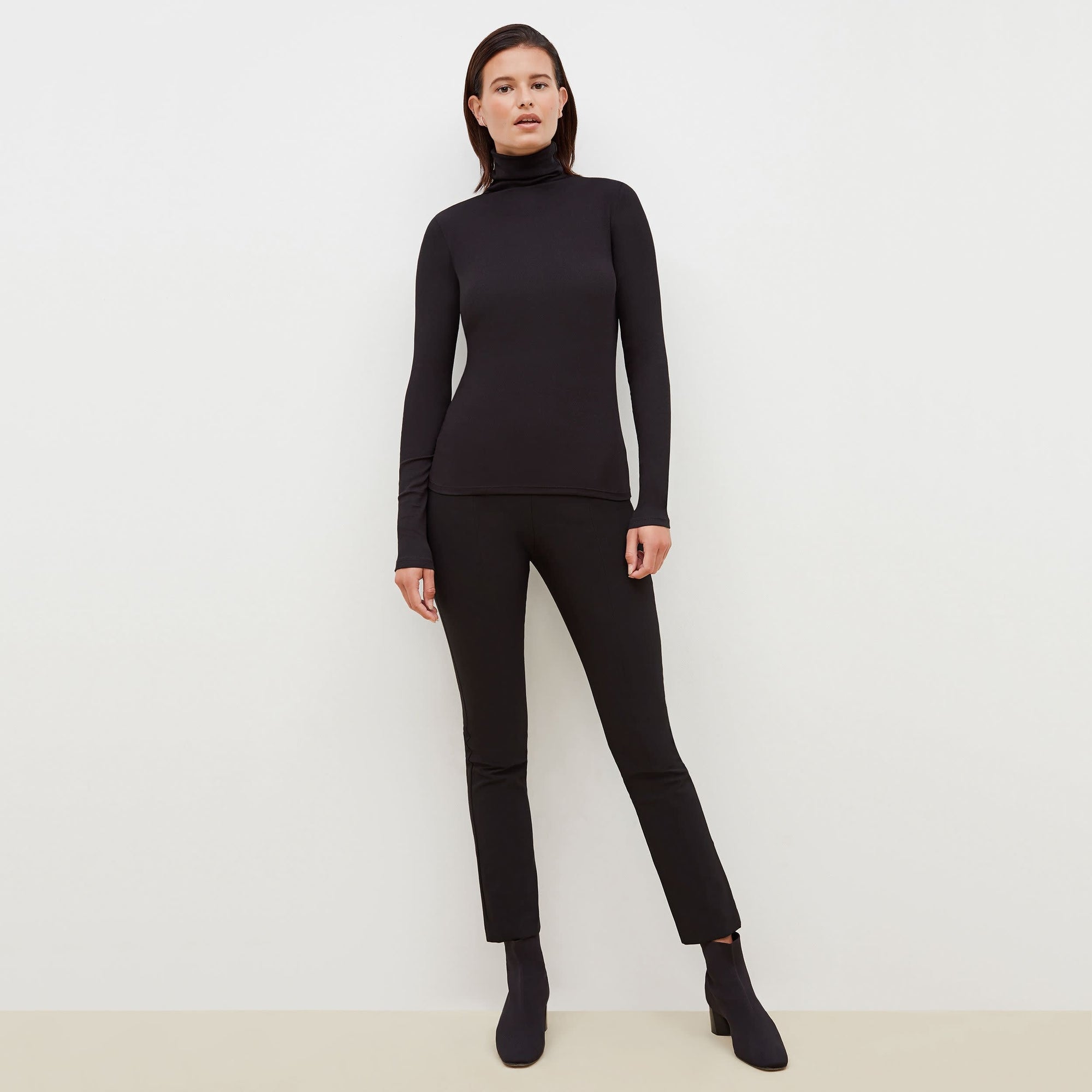 Front image of a woman standing wearing the Foster Pant—Everstretch in Black | Exclude