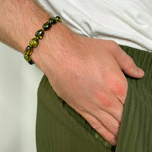Shimmering beaded Green Zircon nugget bracelet with shades of green, yellow, and olive on a gold lobster clasp, on a wrist.