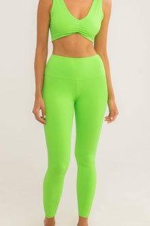 Bright green high-waisted legging with wide ribbed band, shown as part of matching two-piece set.