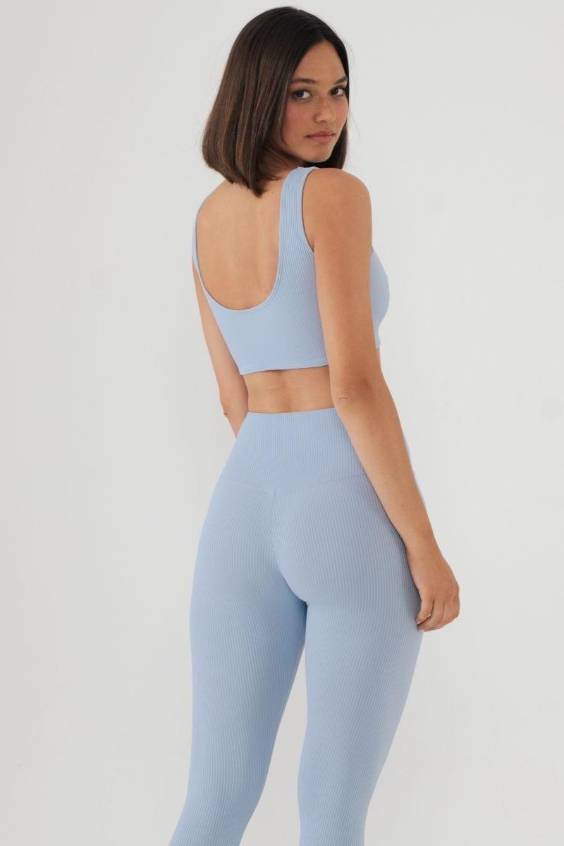 Light blue ribbed bikini top with scoop neckline and sleeveless design, shown on model from back view.