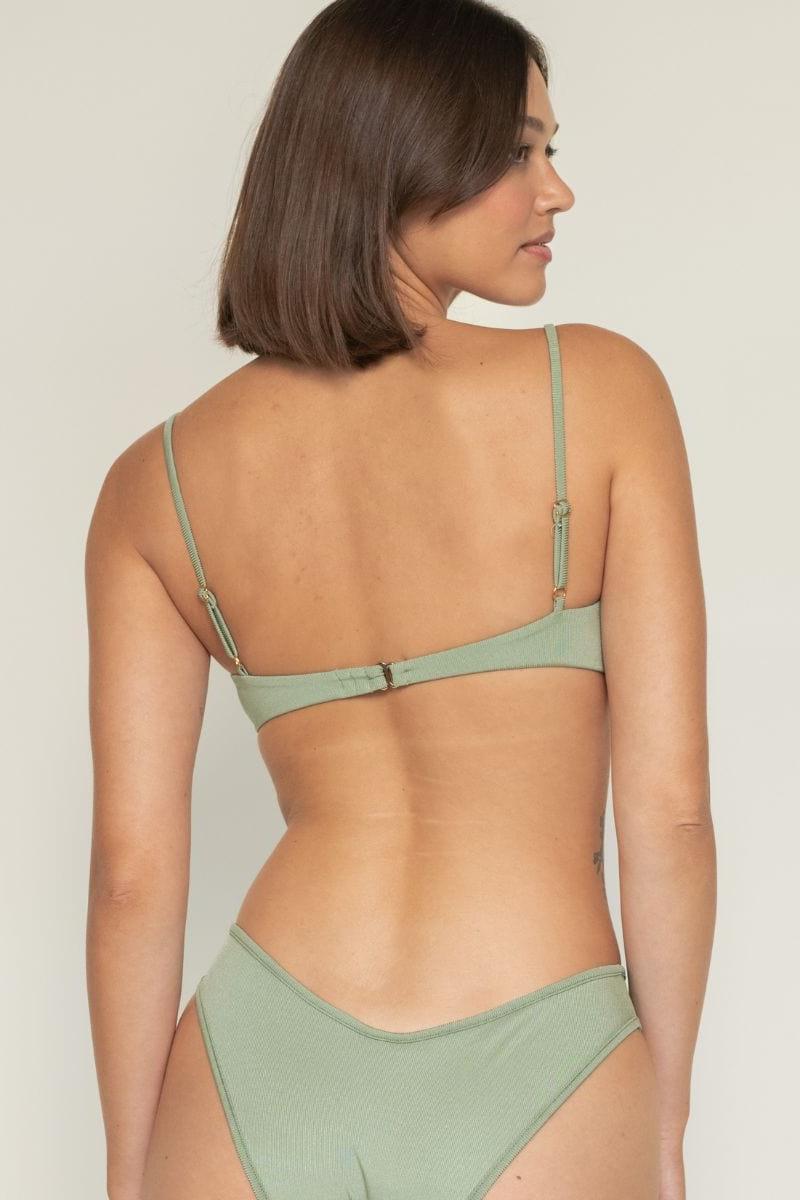 Sage green ribbed bikini top with thin shoulder straps and hook-back closure, shown on model from behind.
