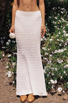 White textured maxi skirt with elastic waistband worn with tan sandals.