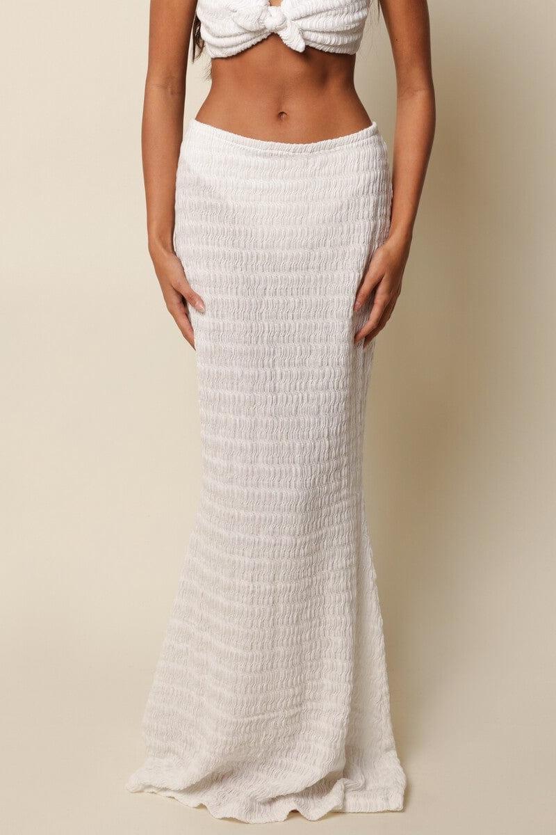White ribbed maxi skirt with high waist and textured knit fabric.
