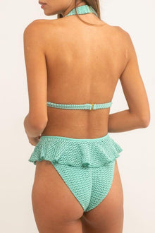 Turquoise crochet bikini bottom with ruffled waistband and textured knit fabric, back view.