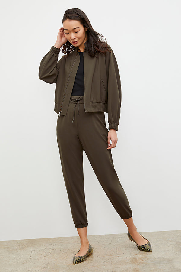 Back image of a woman standing wearing the Delaney Jogger—OrigamiTech in Olive | Grid Hover | Exclude